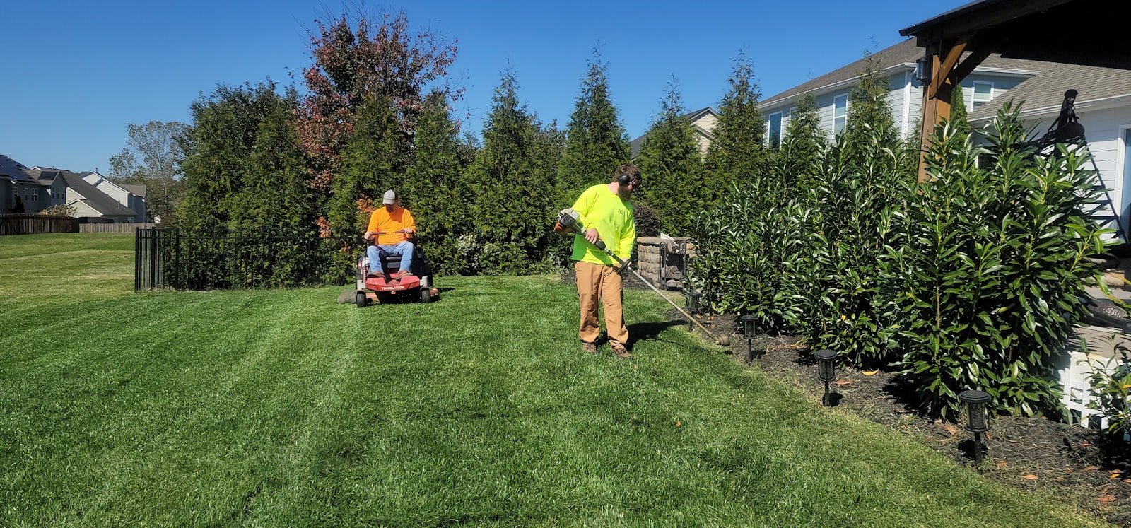 Green Knack crew mowing and trimming a Tampa Bay backyard